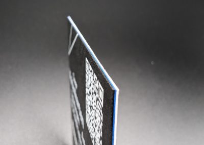 Visitenkarte mit schwarzem Karton, blauem Kern und Weißdruck