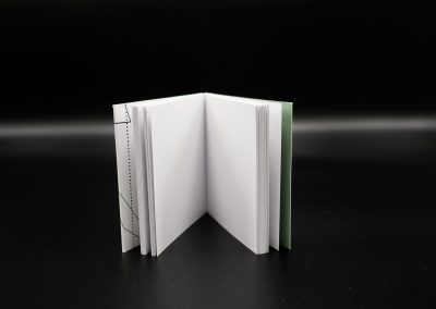 Detailansicht einer Hotmelt Klebebindung bei einem Buch mit Paperback und perforiertem Klapper